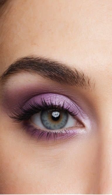 A close-up of a pair of eyes with a sophisticated and long-lasting eye makeup look in shades of lilac and lavender
