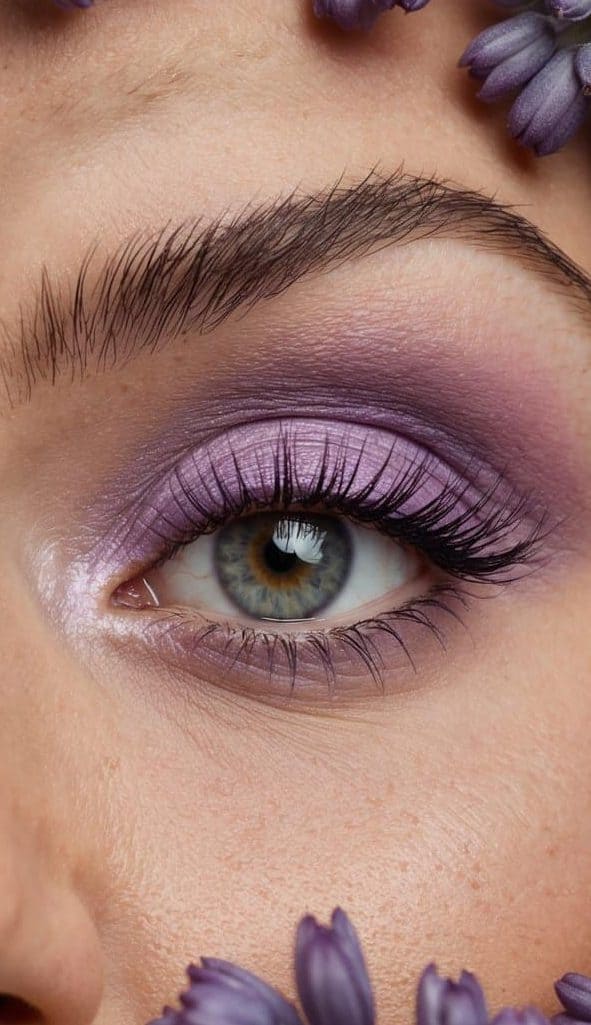 Soft lilac eye makeup palette surrounded by dewy lavender flowers