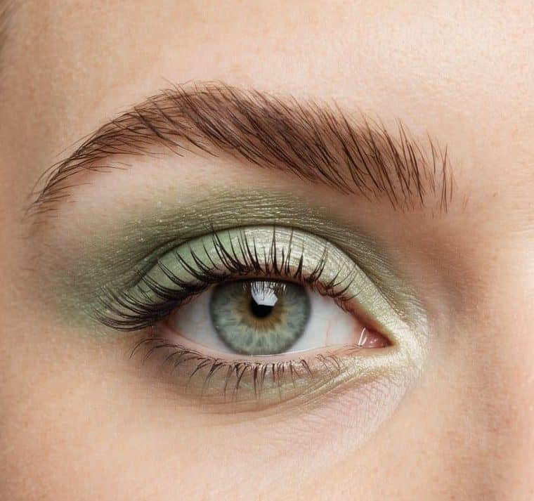 A close-up of a pastel green eye with soft, refreshing makeup, incorporating shimmer and a hint of sparkle