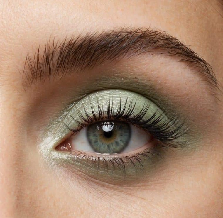 Soft pastel green eye makeup on an eye, with subtle shimmer and a hint of sparkle