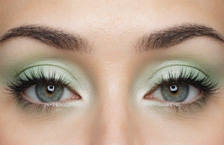 A close-up of a pair of eyes with soft and refreshing pastel green eye makeup, incorporating mint julep mystique