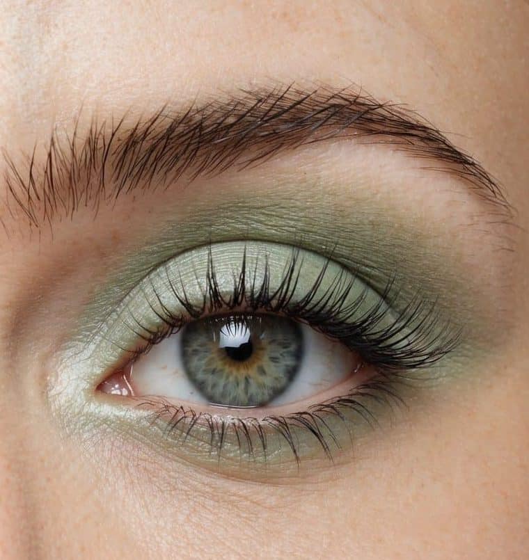Soft pastel green eye makeup on a closed eyelid, with a hint of shimmer catching the light