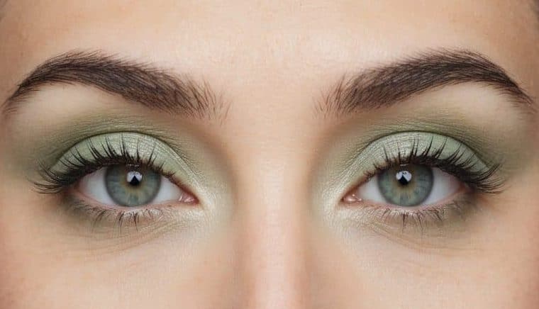 A close-up of a pair of eyes with soft and refreshing pastel green eye makeup, incorporating subtle shading and blending techniques