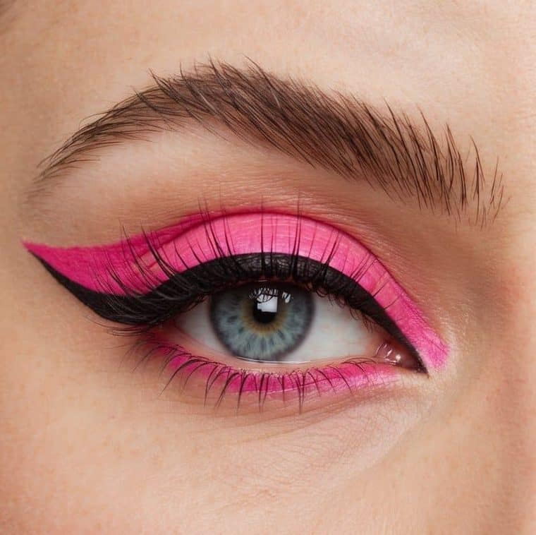 A close-up of a bold hot pink winged eyeliner look with pastel pink liner, against a clean background