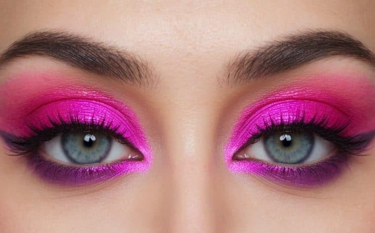 A close-up of a pair of eyes with vibrant pink and purple eyeshadow, creating a romantic and colorful makeup look