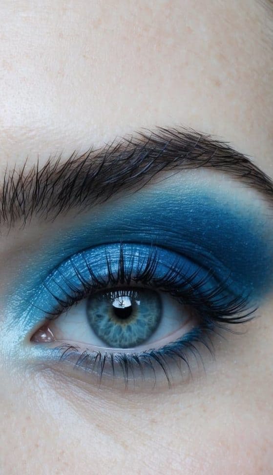 Soft sky-blue moonlight shines on a tranquil landscape, reflecting in a serene body of water