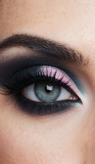 A close-up of a pair of eyes with bold and dramatic makeup, featuring dark shadows and pastel hues, creating an edgy and striking look