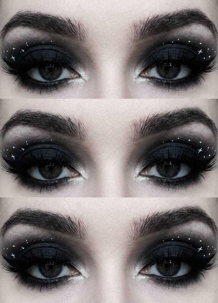 Close-up of a trad goth eye makeup look featuring matte black eyeshadow and small white star designs scattered across the outer lid.