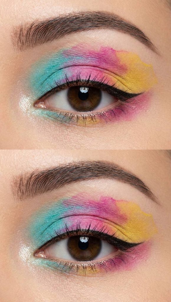 Soft, painterly eye makeup featuring overlapping shades of teal, pink, and yellow in a seamless, abstract gradient on the eyelid.
