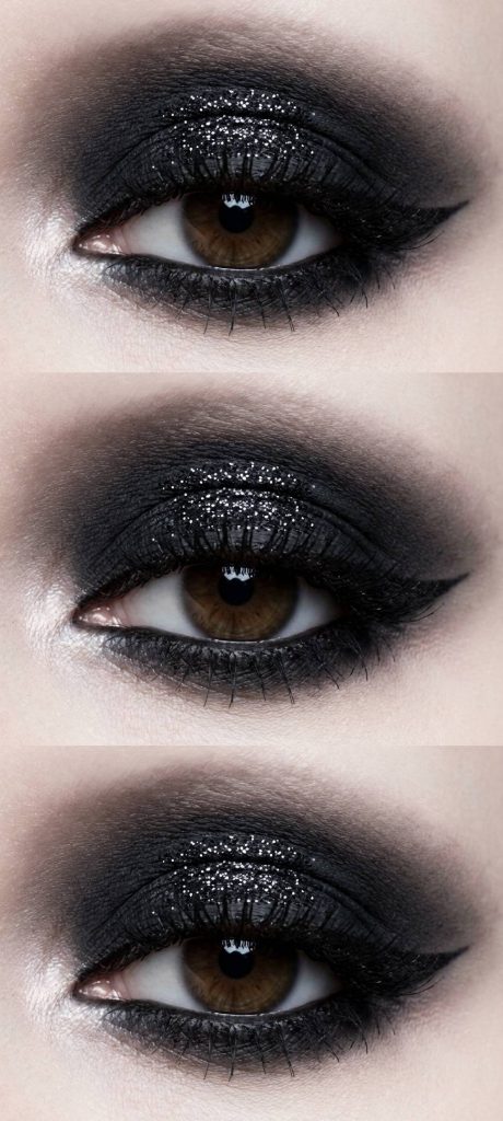 Eye makeup look with dark black shadow haloed around the lid, finished with scattered silver glitter creating a smoky eclipse-like effect.