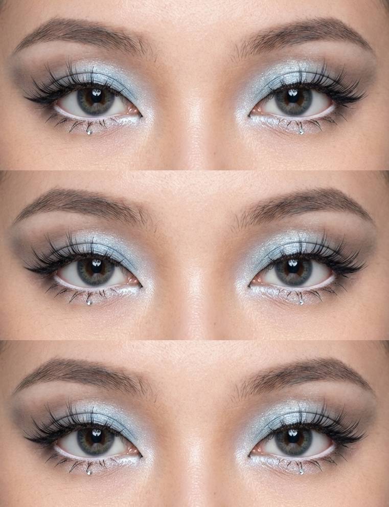 Close-up of douyin eye makeup trend with shimmering blue eyeshadow, wispy black lashes, and rhinestones placed beneath the lower lash line.
