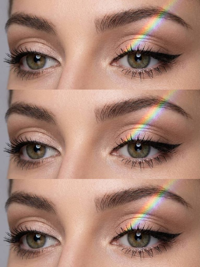 Crazy eye makeup looks featuring champagne-toned eyeshadow, winged black liner, and a natural rainbow light reflecting diagonally across the eyelid.